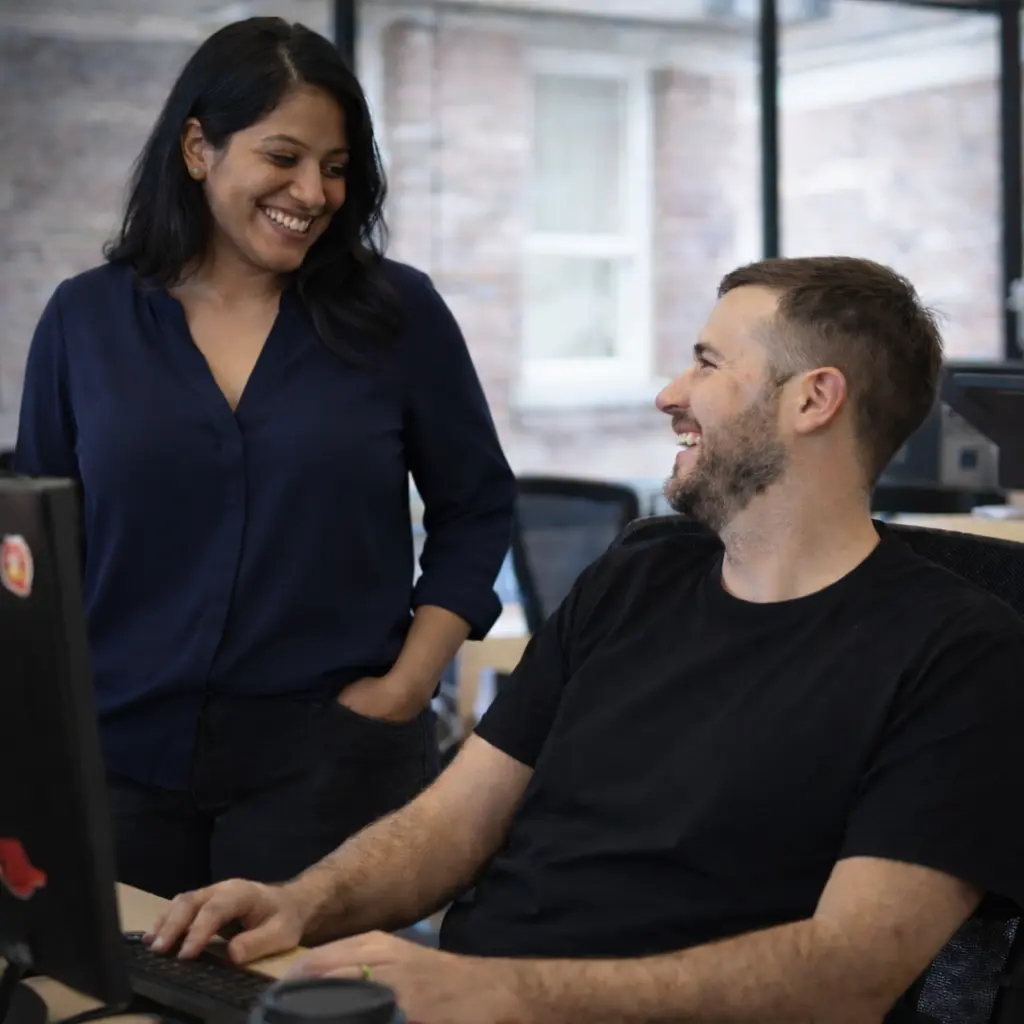 Image of Squiz employees smiling at a desk