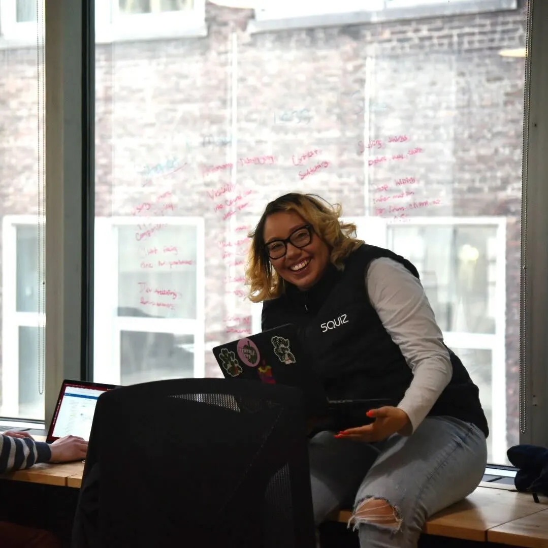 Image of a Squiz employee with laptop, smiling