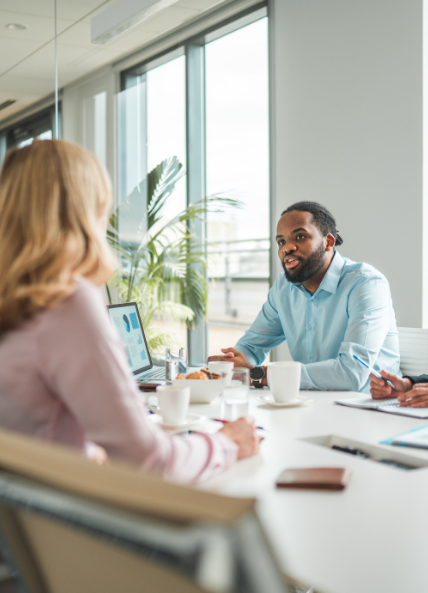 Man speaking to a women across a table in a work environment