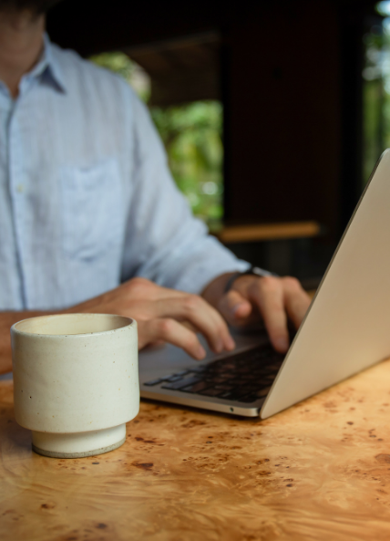 Person sat at laptop with a coffee