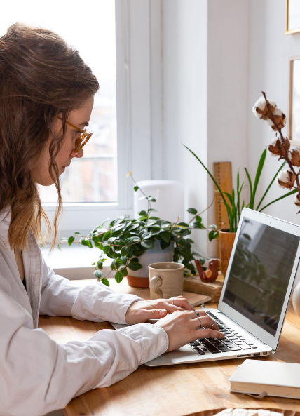 Lady sat at a laptop at her desk working