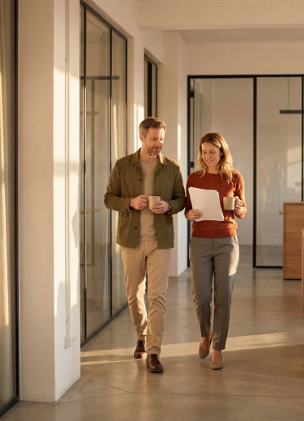 Man and women walking through an office talking 